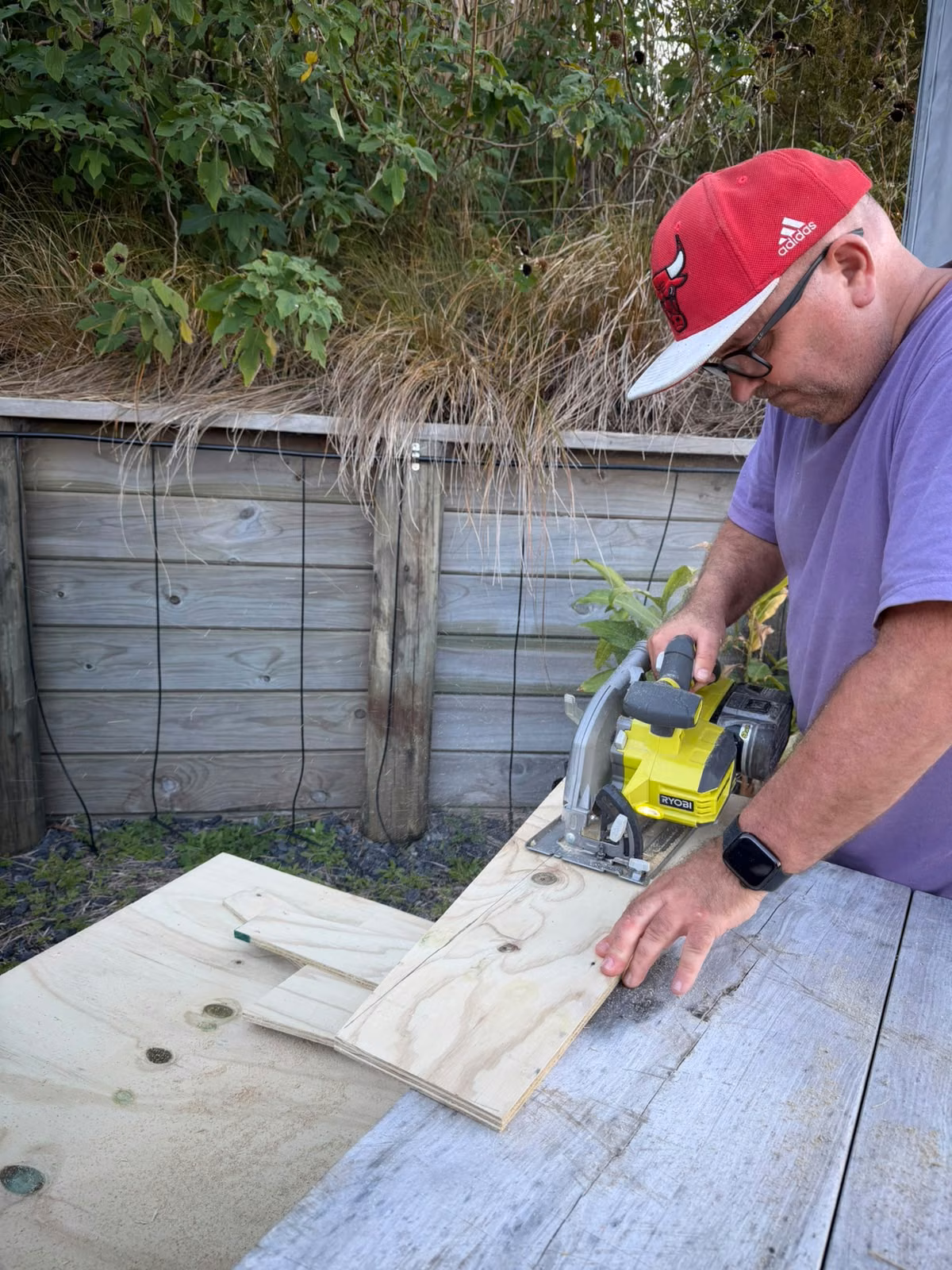 Mark cutting treated plywood for Luna's kennel with a cordless circular saw