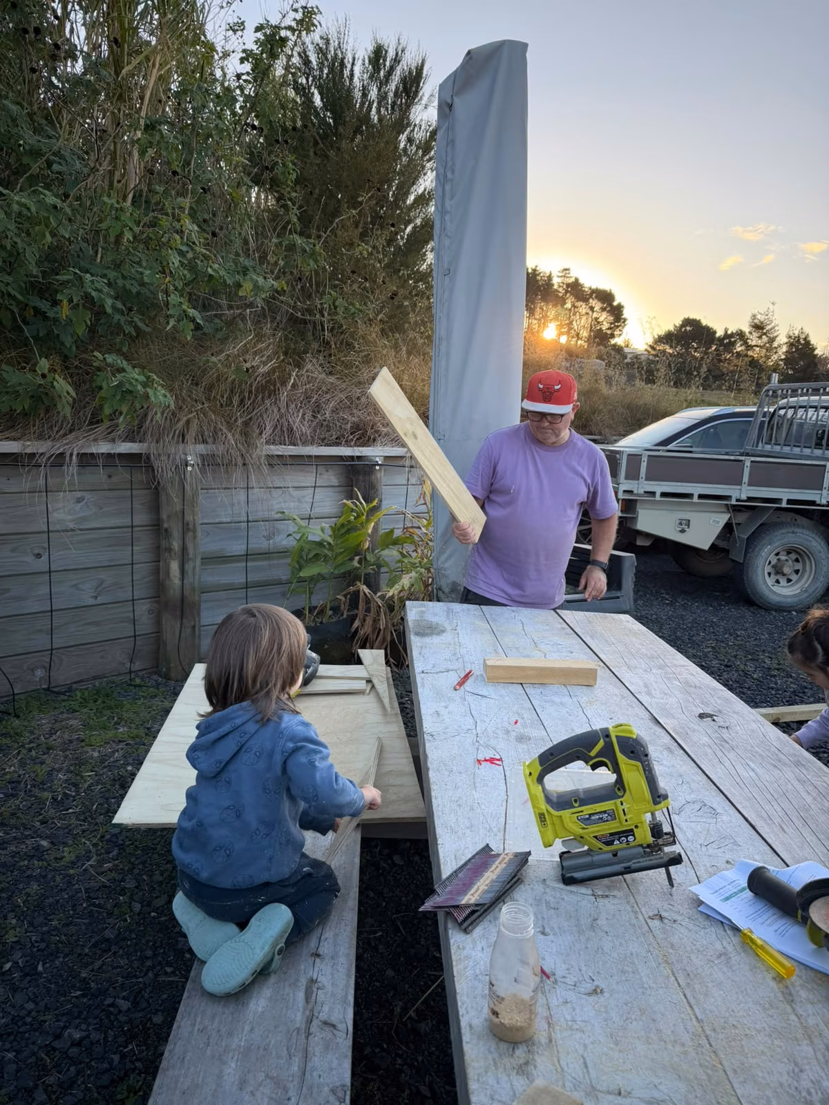 Mark and the children laying out plywood and framing timber for Luna's kennel