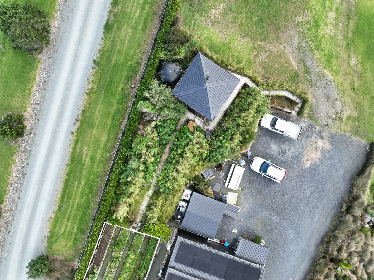 Aerial view of the house, food forest, and vegetable beds at Āhuru Mōwai