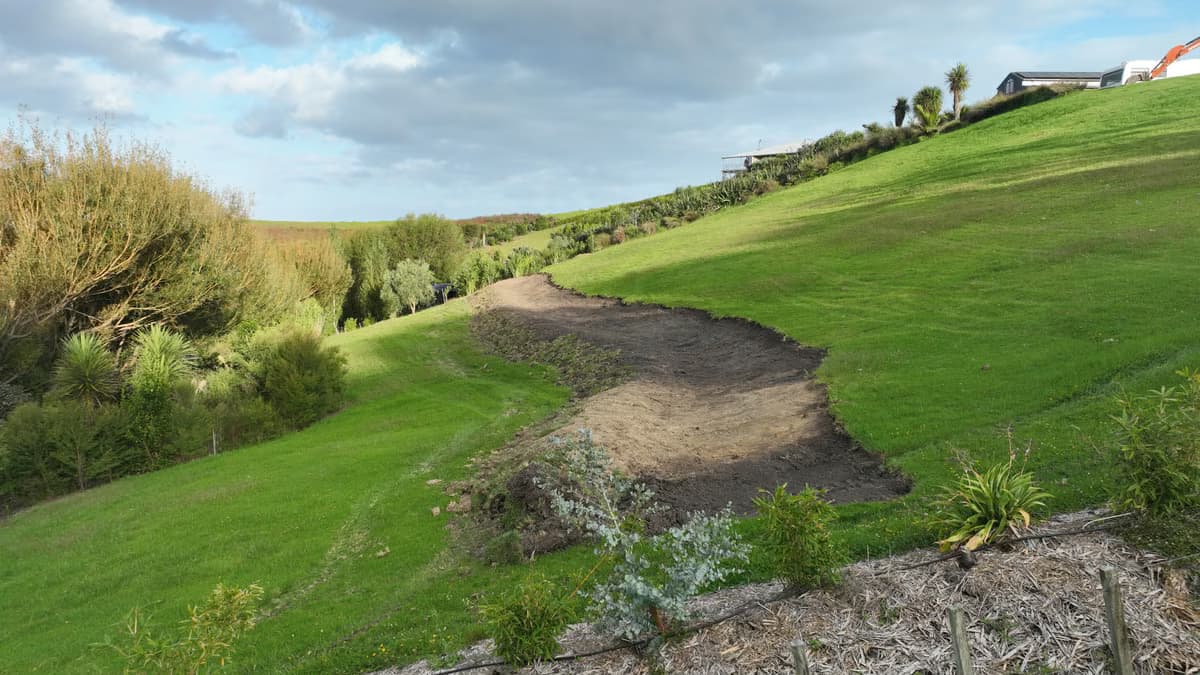 Freshly worked hillside with contour lines visible and the wider valley beyond